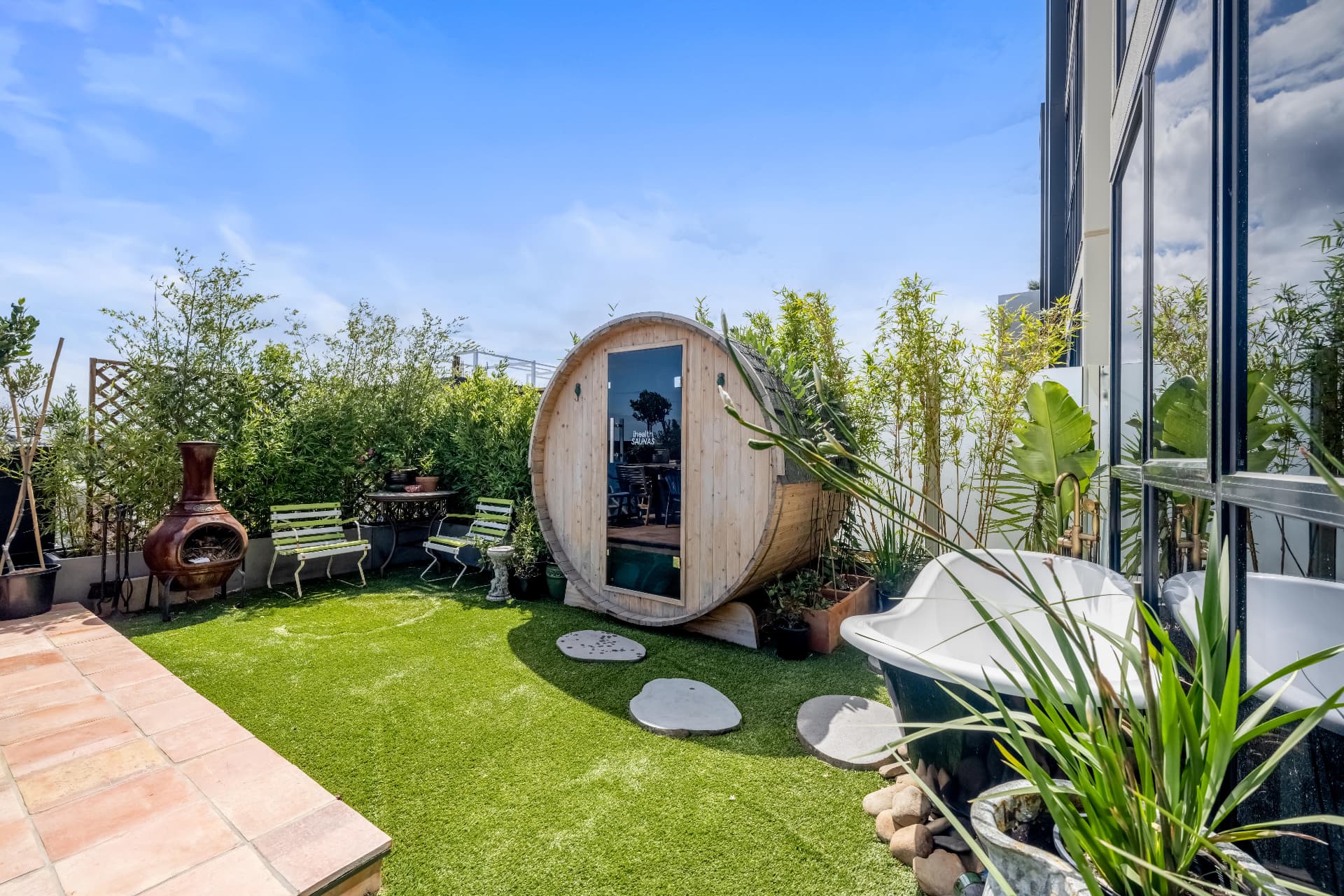 Rooftop terrace with barrel sauna, clawfoot outdoor bath and lawn