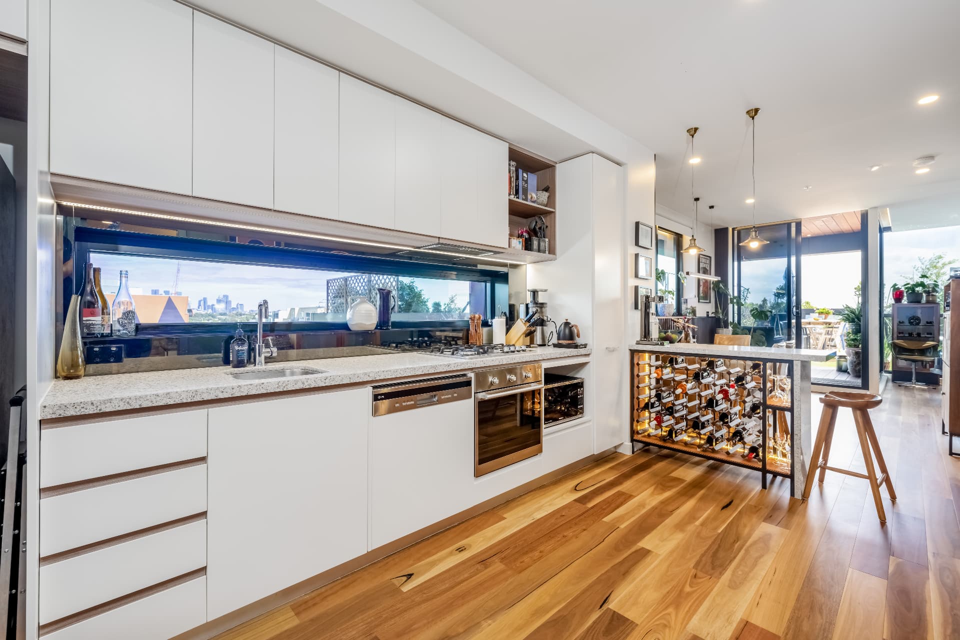 Kitchen with stone benchtops and city-view window splashback